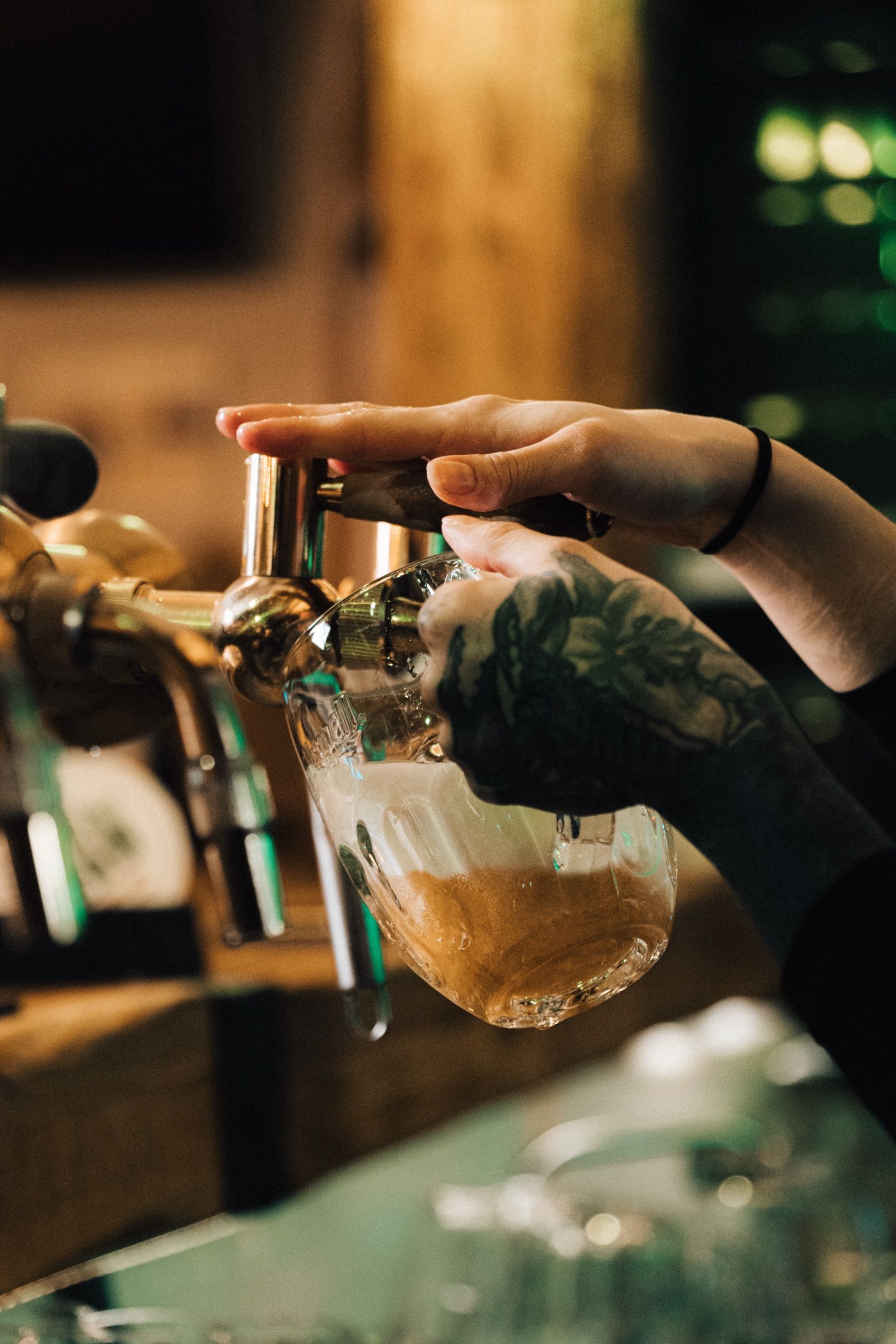 Tetovaná ruka čepuje pivo