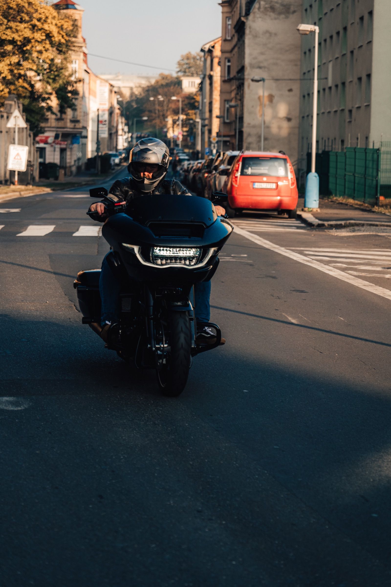 Motorkář přijíždí ulicí ke KNAKu